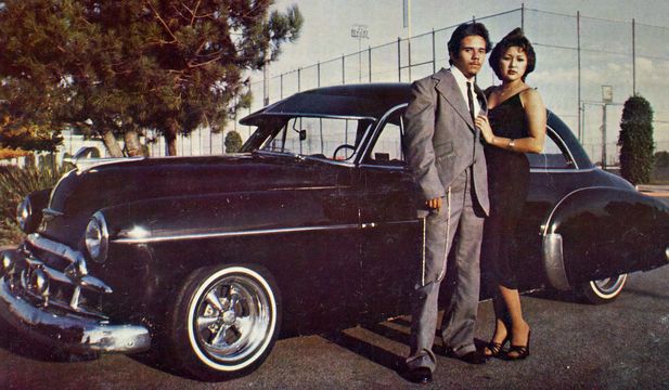 Photo of a couple standing in front of a vintage car