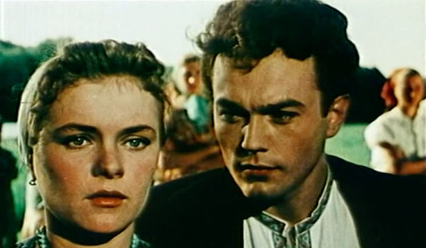 a man in suit starring at another woman next to him