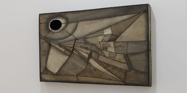 an abstract artwork hanging on a white wall