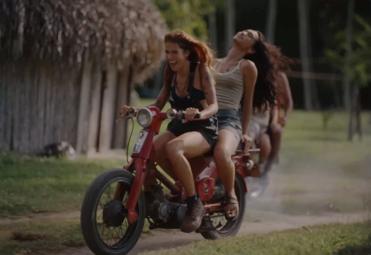 image of two people with long hair riding motorcycle