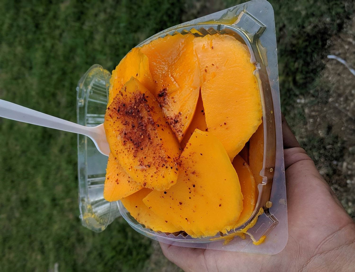 A container of fruit covered in Taijin chili powder