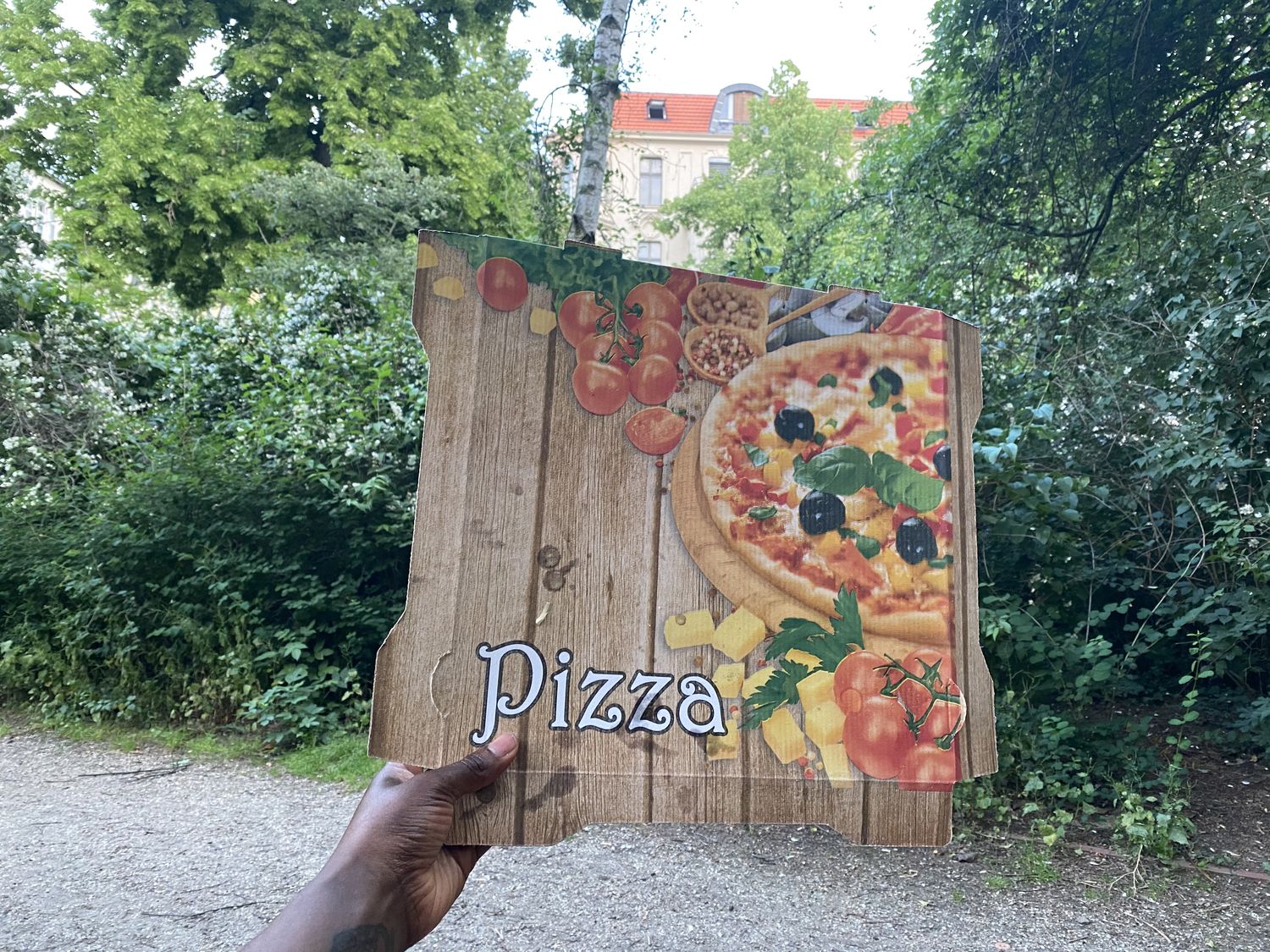 A hand holding a pizza box