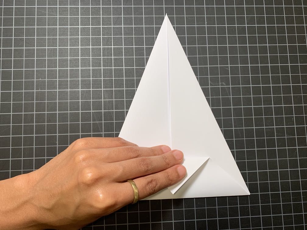 Folding top point of middle triangle to bottom of folded piece of paper