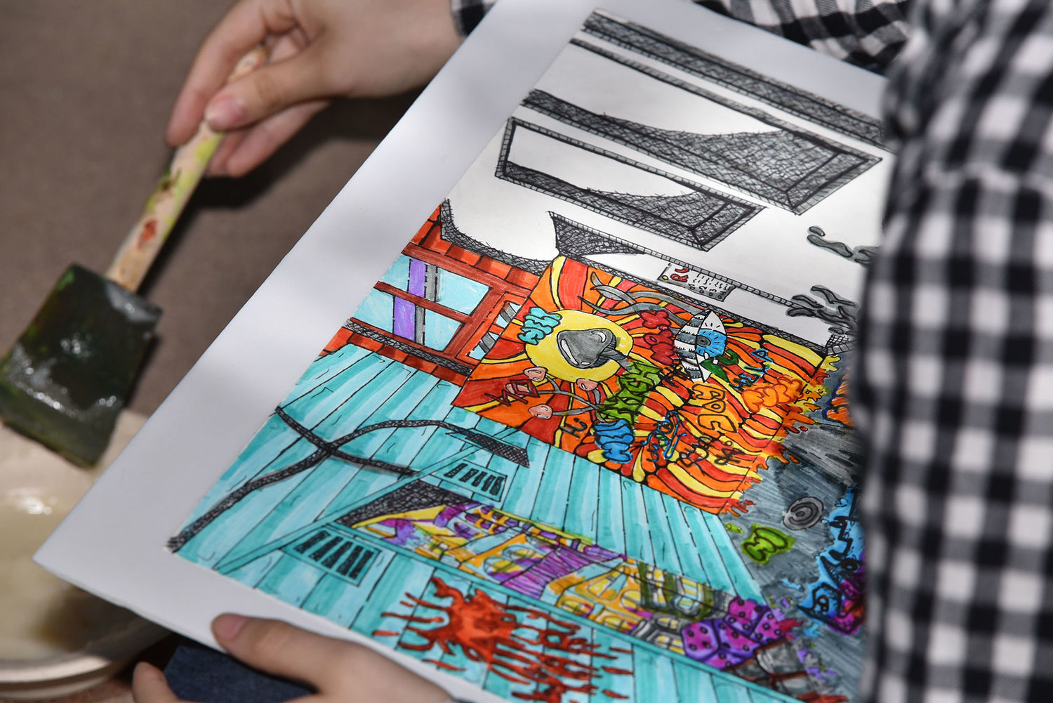 A photograph of a colorful, intricate drawing in someone's hands