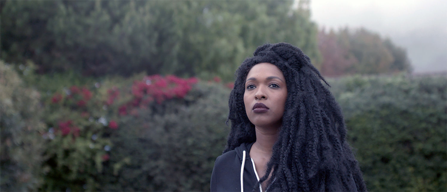 Film still of a Black woman with braids