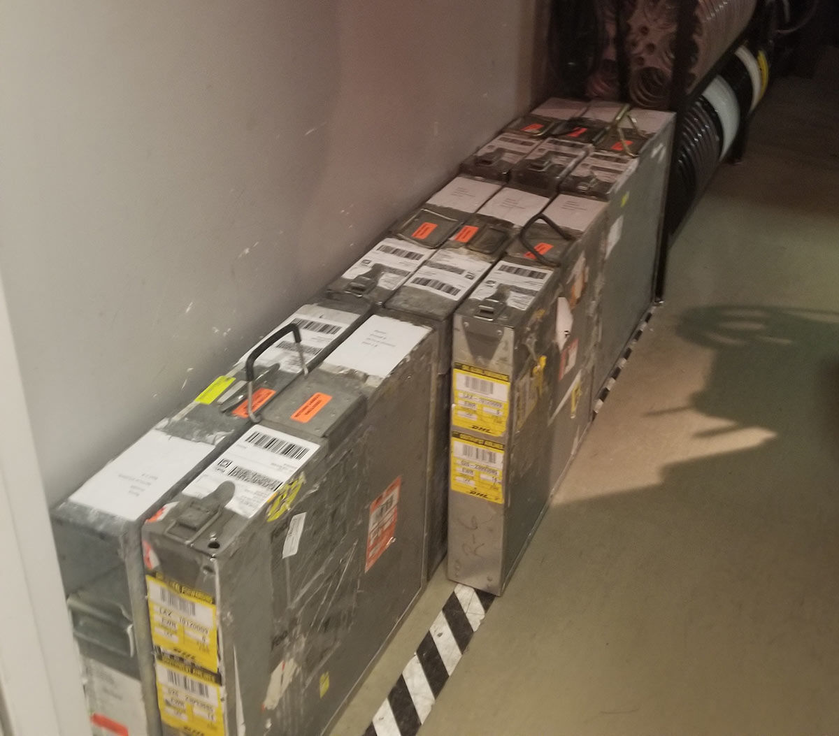 The 8 film cases containing the reels of film are stacked on the floor.