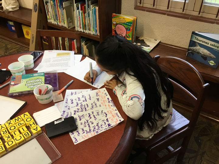 A young child writes a ‘calling card’ inspired by Adrian Piper’s work.