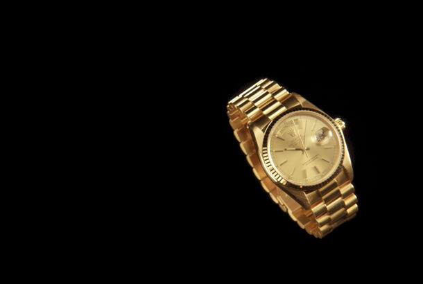 A gold watch on a black background