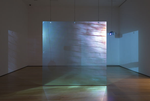 Video installation with images being projected on either side of a floating screen