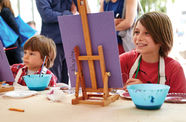 Two children paint at easels