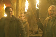 Two men and a women stand with torches