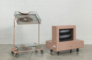 A pink TV monitor hooked up to a rolling stand