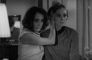 Still from the film Duet for Cannibals (1969) showing a woman holding another woman's head as they both look forward