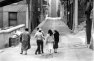 Still from the film The Exiles (1961) showing a group of people walking down an alley