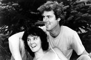 Still from the film Return of the Secaucus Seven (1979) showing a woman leaning against a man, both seated and smiling