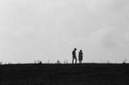 Still from the film Spring Night, Summer Night (1967) showing two people standing on a hill, in shadow