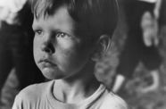Still from the film Little Fugitive (1953) showing a close-up of a young boy frowning