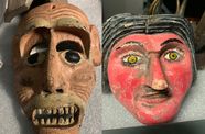 Two masks. On the left a brown mask with bared teeth and black eyes. On the right, a mask with a red face, black hair and yellow eyes.