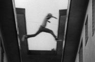 Still from the film Killer of Sheep (1978) showing a boy leaping from one rooftop to another