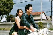Still from the film Better Luck Tomorrow (2003) showing a young Asian American couple riding a motorcycle
