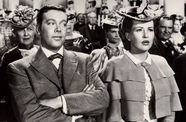 Still from the film The Shocking Miss Pilgrim (1947) showing a man looking askance at a women seated next to him