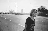 Still from the short film "Last Light" (2020) by Carmen Argote, showing a woman in a protective face mask walking down a Los Angeles road