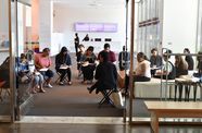 Several teachers sit on folding chairs in the Hammer lobby. 
