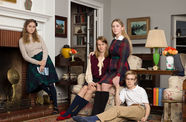 A family portrait of four preteens, arranged in a living room