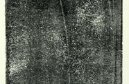 a field of textured, gritty black color sits on top of an off-white background, with a border of off-white showing around the black. The off-white background shows through the black color in speckled spots across the whole area.