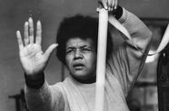 Woman stands with her hands up, one hand holding a long strip of film.