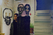 Woman in a brick room with paintings on the walls. 
