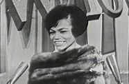 Black and white photo of a woman with a microphone.