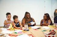 Two women and two children do arts and crafts together. 