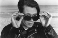 A man holds his sunglasses on his face. 