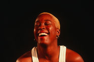 woman in a tank top with short hair laughs