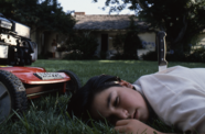 A boy lays on grass.