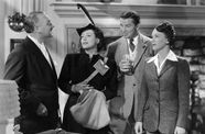 Two men and two women stand talking. 