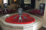 Alien in a bath tub shaped like a heart.
