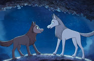 Two cartoon wolves stand, looking at each other. 