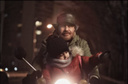A man holds his child in a warm puffy jacket.