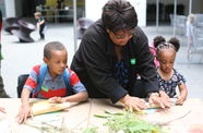 Hammer employee working with two kids to make art with leaves.