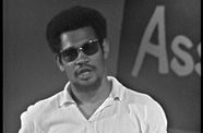 Still from TV program showing poet Alvin Saxon Jr reading his work and addressing the camera