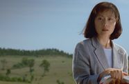 Woman holding books looks past camera