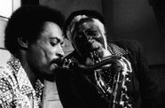 Two men play the saxaphone