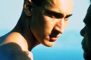 The light hits the face of a central character intensely. This close up portrait is against the blue of the sky.