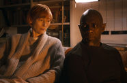 Still from the film "Three Thousand Years of Longing" (2022), showing Tilda Swinton sitting next to Idris Elba on a couch