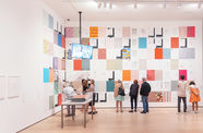 A small group of people looking at a colorful installation on a gallery wall
