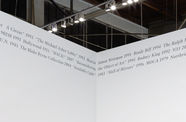 Grey text sits in the top corner meeting of two white walls.