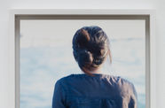 Color photo the back of a woman as she looks out over a body of water