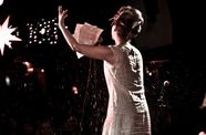 Woman singing from sheet music with a black background and starlights